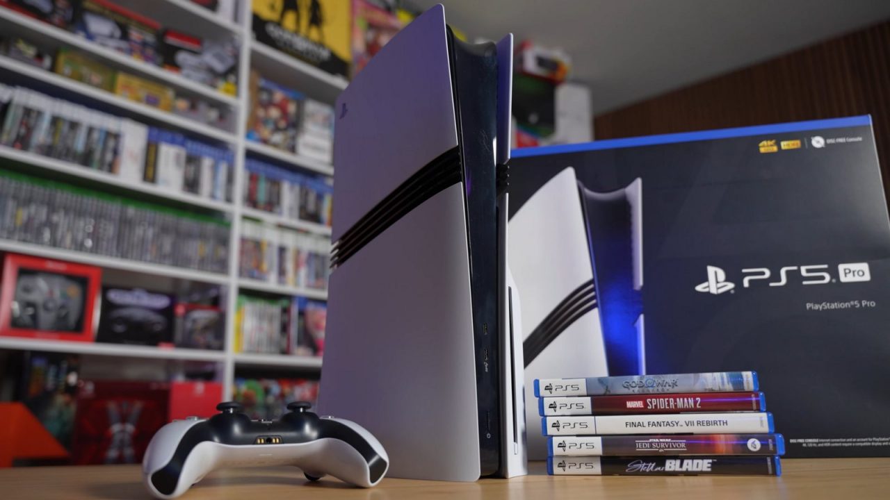 White PS5 Pro console standing beside its retail box, a DualSense controller and game cases