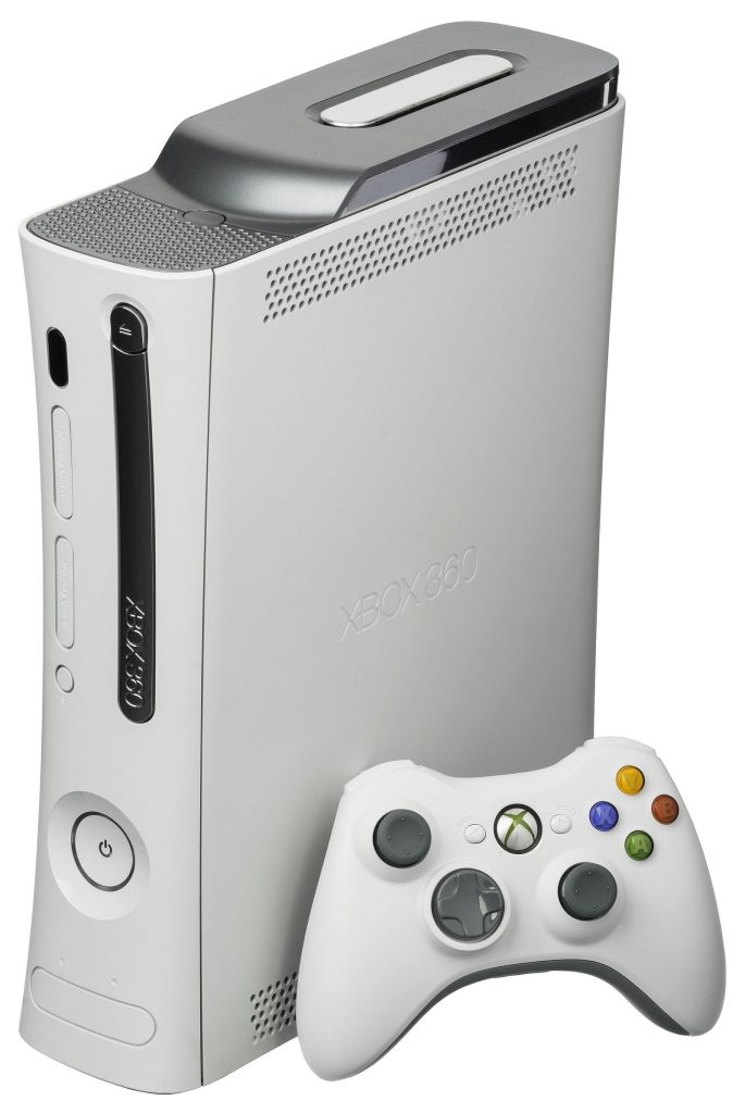 White Xbox 360 console standing upright with a wireless controller